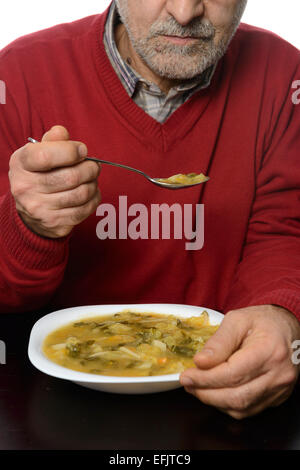 Mann mittleren Alters Essen Gemüsesuppe Stockfoto
