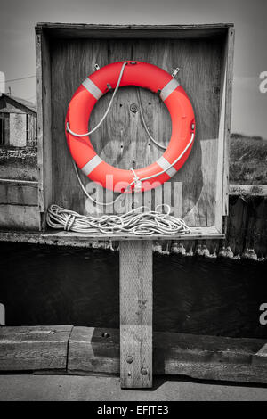 Orange Lebensretter oder Boje hängen in Holzkiste auf Dock. Prince Edward Island, Kanada, selektive Färbung. Stockfoto
