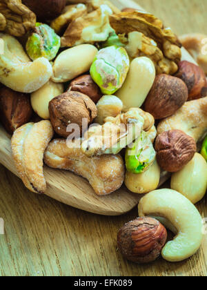 Gesunde Bio-Ernährung hoch Fettsäuren essen und Küche. Closeup Sorten Sortiment Mix aus Nüssen auf Holzlöffel. Stockfoto