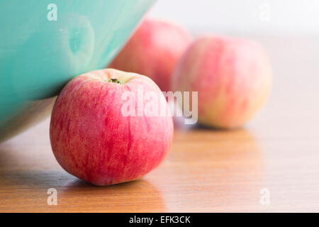 Nahaufnahme von roten Äpfeln auf Tisch und grünen Fruchtschale Stockfoto