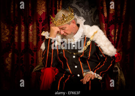 Nachdenklich und besorgt König auf seinem Thron sitzen Stockfoto