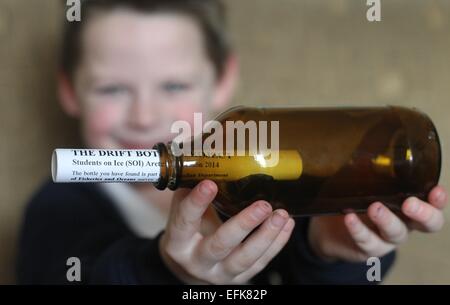 Ballymoney, Nordirland. 5. Februar 2015. Schuljunge Noah White ist mit seiner Flasche abgebildet. Eine Flaschenpost, die über 2000 Meilen zurückgelegt hat, wurde diese Woche von Ballymoney Schuljunge Noah White gefunden. Die Flasche wurde auf dem östlichen Strand in Portrush gefunden. Wenn die Familie die Flasche geöffnet, die sie erkannt hatte es aus Grönland gereist, wo es von einem arktischen Expedition-Team im Juli, in geworfen wurde. Eine Gruppe von kanadischen Studenten studierten Wasserfluss. Im Rahmen des Projekts wurde eine Anzahl von Nachrichten in einer Flasche ins Meer. Bildnachweis: Steven McAuley/Alamy Live-Nachrichten Stockfoto