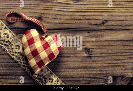 Stoff-Herz mit Spitze Holz Hintergrund überprüft Stockfoto