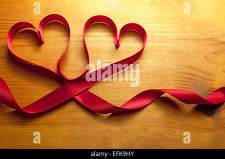 Rote Schleifen hergestellt aus Seide in Form von Herzen Stockfoto