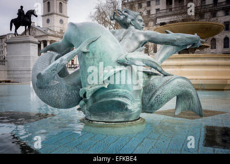 Statue von einer Meerjungfrau mit Delfinen in den Brunnen des Trafalgar Square, mit einer Statue von König George IV auf seinem Pferd in den Rücken Stockfoto