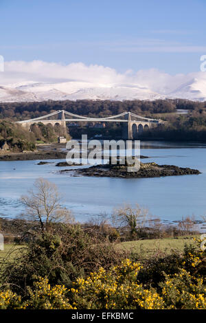 Menai Hängebrücke über die Menaistraße mit Schnee auf Carneddau Berge von Snowdonia hinaus. Menai Bridge Anglesey Wales UK Stockfoto