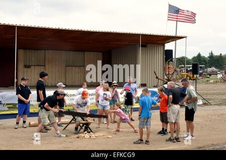 Eine Gruppe von Menschen lernen, wie man eine zwei-Mann-Ablängsäge zu verwenden, auf der "Dampf und Traktor" in Milton, Ontario, Kanada Stockfoto