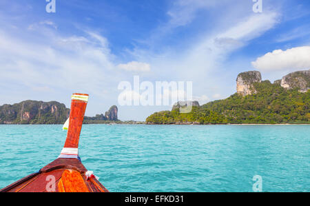 Holzboot und eine tropische Insel im Abstand. Stockfoto