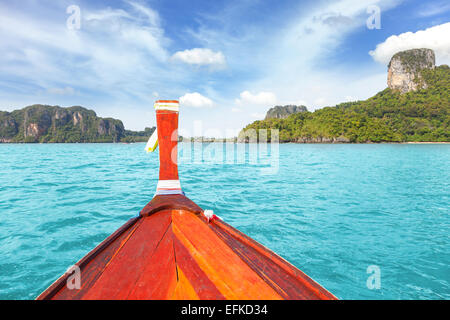 Holzboot und eine tropische Insel im Abstand. Stockfoto