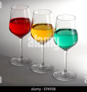Drei Gläser Wein mit rot, gelb und grün gefärbte Flüssigkeit gefüllt.  Vertreter der Ampel Stockfoto