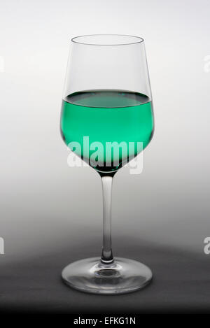 Weinglas mit grün gefärbte Flüssigkeit Stockfoto