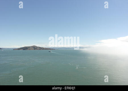 Blauer Himmel-Blick von der Golden Gate Bridge auf Angel Island über blaugrün Gewässer mit Advektion Nebel, California San Francisco Bay Stockfoto