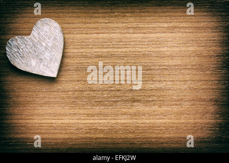 Herz aus Holz auf Holz verblasste Grunge Hintergrund Stockfoto