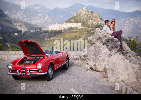 Paar sitzen warten auf Rettung mit einem aufgeschlüsselt Oldtimer in den französischen Bergen Stockfoto