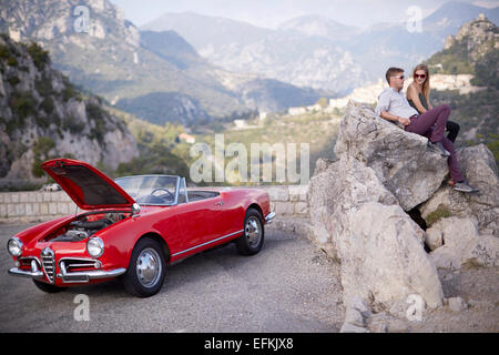 Paar sitzen warten auf Rettung mit einem aufgeschlüsselt Oldtimer in den französischen Bergen Stockfoto