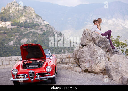 Paar sitzen warten auf Rettung mit einem aufgeschlüsselt Oldtimer in den französischen Bergen Stockfoto