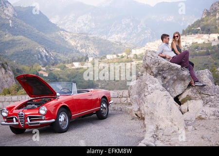 Paar sitzen warten auf Rettung mit einem aufgeschlüsselt Oldtimer in den französischen Bergen Stockfoto