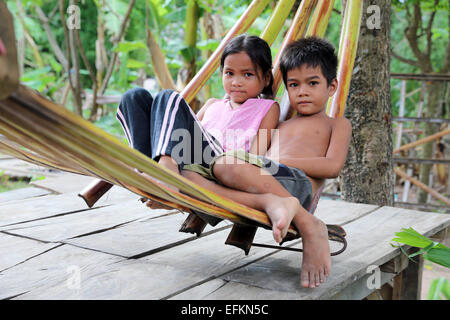 jungen und Mädchen sitzen in einer Hängematte Palme Blätter. Saepean Dorf in Kambodscha Stockfoto