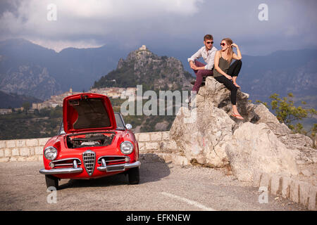 Paar sitzen warten auf Rettung mit einem aufgeschlüsselt Oldtimer in den französischen Bergen Stockfoto