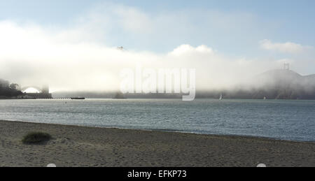 Blauer Himmel-Blick vom Sandstrand an Crissy Field über San Francisco Bucht, weißer Nebel verdeckt Golden Gate Bridge, San Francisco Stockfoto