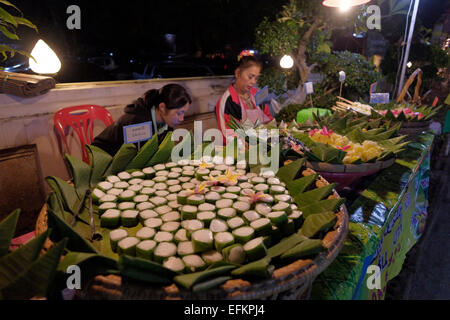 Verkäufer, die traditionelle gedämpfter Klebreis in Banana Leaf in einer Garküche auf Chaikhong Straße, die am Wochenende abends gewickelt verwandelt sich in eine Straße zu Fuß in die Stadt Chiang Khan in der Provinz Loei in der nordöstlichen Region Isaan am Südufer des Flusses Mekong Laos. Thailand Stockfoto