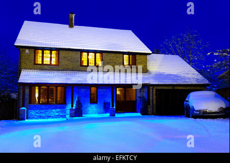 Nachtaufnahme eines großen, im Executive-Stil eingerichteten Einfamilienhauses mit 4 5 Schlafzimmern, das im Winter von Schnee bedeckt ist, Kent UK Stockfoto