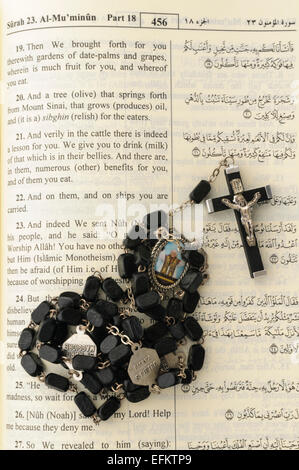 Katholischen Rosenkranz sitting on Top of eine offene Qu'ran. Stockfoto