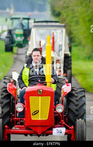 Langen Reihe von Traktoren auf einer Landstraße im Rahmen eines geförderten Traktors laufen. Stockfoto