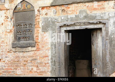 Buddhistische Steinrelief und geschnitzten hölzernen Türsturz und Tür auf roten Backsteinmauer auf dem hinteren Teil der VV. Khenchen gegründet TT. Yangtse Stockfoto