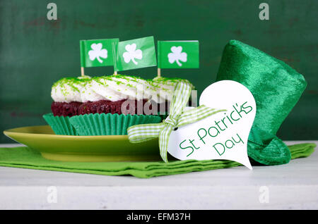 Happy St Patricks Day Cupcakes mit grünen Thema Dekorationen auf Vintage-Stil grün Holz Hintergrund. Stockfoto