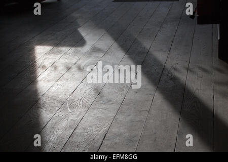 Schatten- und Lichtmuster, erzeugt durch Sonnenlicht, das durch ein Fenster filtert, auf Holzdielen eines Cafés in Cambridge, Großbritannien Stockfoto