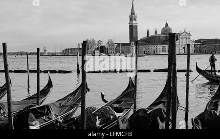 Gondeln und Gondoliere Rudern auf die Lagune von Venedig mit Insel und Kirche von San Giorgio Maggiore im Hintergrund Veneto Italien Europa Stockfoto