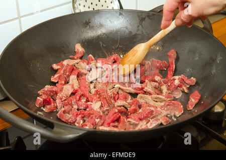 Rindfleischstreifen in einem Wok anbraten Stockfoto