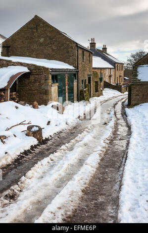 Peak District Bauernhof im Winter mit Schnee bedeckt Feldweg und Steinbauten. Stockfoto