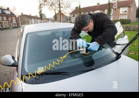 Ein Soldat aus "Carglass" ist einen Riss in der Windschutzscheibe eines Autos vor Ort reparieren. Stockfoto