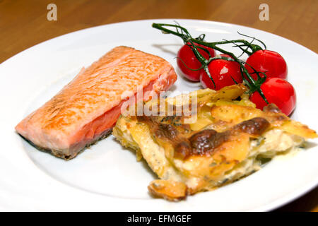 Lachs mit Kartoffel-Gratin und Cherry-Tomaten Stockfoto