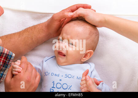 Eltern zu beruhigen ein schreiendes Baby auf seinem Kopf streicheln Stockfoto