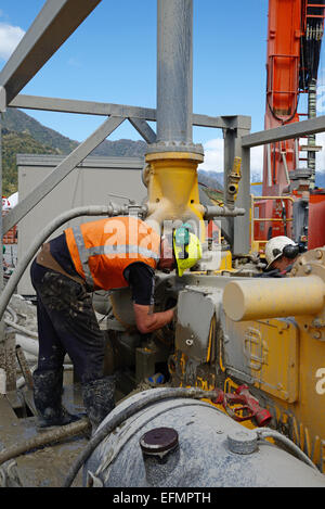 WHATAROA, NEW ZEALAND, 5. Dezember 2014: Ein nicht identifiziertes Rigger reinigt die Spülpumpe für tiefe Schuld Drilling Project. Stockfoto