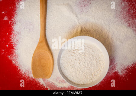 Koch-Konzept. Vorbereitung zum Backen, Backen Zutaten, um einen Kuchen, Weizenmehl auf roten Silikonmatte, Ansicht von oben Stockfoto