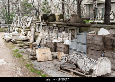 Istanbul Archäologie-Museen-Garten Archäologische Artefakte Istanbul Türkei | ISTANBUL, Türkei — Geschnitzte Grabstelen und eine kopflose bekleidete Statue ruhen auf Holzpaletten im Garten der Istanbul Archäologie-Museen. Der Komplex befindet sich an dem Hang, der Gülhane-Park mit dem ersten Hof des Topkapi-Palastes verbindet, im historischen Fatih-Bezirk von Istanbul. Um eine Sammlung von etwa einer Million Objekten zu verwalten, nutzt das Museum sein umliegendes Gelände als Freiluft-Lapidarium und lagert langlebige Steinaltertümer, die die Kapazität der Innengalerien übersteigen. Stockfoto