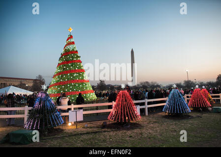 National Christmas Tree State Trees Washington DC / WASHINGTON, D.C. – State Trees umgeben den National Christmas Tree auf der Ellipse, einem Parkbereich südlich des Weißen Hauses in Washington, D.C. diese jährliche Weihnachtsausstellung zeigt kleinere, verzierte Bäume, die jeden US-Bundesstaat und jedes US-Territorium darstellen, die in einem Kreis um den zentralen National Christmas Tree angeordnet sind. Das Washington Monument, ein 555 Fuß langer Obelisk, der 1884 fertiggestellt wurde, steht im Hintergrund. Die National Christmas Tree Lighting Ceremony ist eine Tradition des Präsidenten seit 1923, als Präsident Calvin Coolidge die erste anzündete Stockfoto