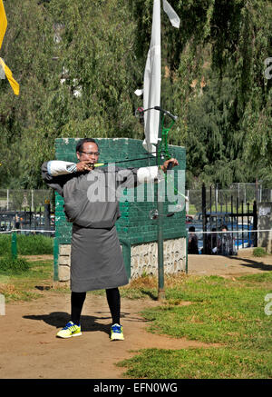 BU00056-00... BHUTAN - Archer in traditioneller Tracht (ein Gho) Teilnahme an einem Turnier 145 Meter auf ein Ziel schießen. Stockfoto