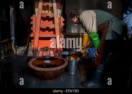 traditionelle Brauerei Technik des chinesischen Reiswein: Frau prüft den Reis Wein gekeltert aus fermentierten Maische. Stockfoto