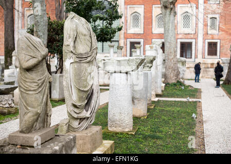 ISTANBUL, Türkei / Türkiye – Marmorstatuen und Säulen stehen in den Gärten der Istanbuler Archäologischen Museen. Die Archäologischen Museen von Istanbul, die sich in drei Gebäuden in den ursprünglich Gärten des Topkapi-Palastes in Istanbul, Türkei, befinden, sind über 1 Million Artefakte zu islamischer Kunst, historischer Archäologie des Nahen Ostens und Europas (sowie der Türkei) und ein Gebäude, das dem antiken Orient gewidmet ist. Stockfoto