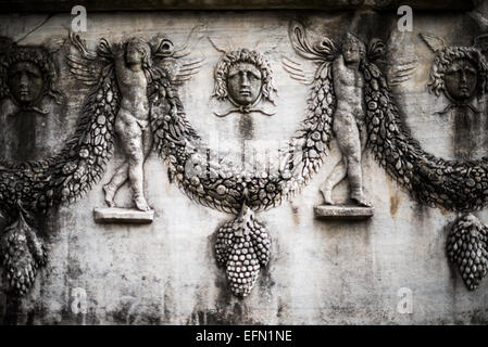 Istanbul Archäologische Museen Sarkophage Relief 2. Jahrhundert n. Chr. Istanbul Türkei / ISTANBUL, Türkei — geflügelte Eroten stützen schwere Fruchtgirlanden auf diesem Steinsarkophag aus dem 2. Jahrhundert n. Chr., ausgestellt in den Istanbul Archäologischen Museen. Die geschnitzten Traubengruppen und zentralen Masken, die sich zwischen den Swags schmiegen, spiegeln beliebte dionysische Themen wider. In der römischen Grabkunst symbolisierte diese Bildsprache der ewigen Ernte den Zyklus des Lebens und der Wiedergeburt und bot dem Verstorbenen eine Vision des postmortalen Überflusses. Stockfoto