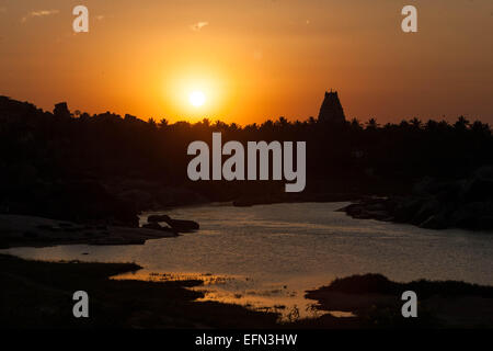 (150208)--KARNATAKA, 8. Februar 2015 (Xinhua)--die Sonne versinkt hinter dem Virupaksha Tempel von Hampi im Bellary District of India Bundesstaat Karnataka, 6. Februar 2015. Spitznamen wie "Hampi: The Lost World", die strenge, grandiose Website von Hampi war die letzte Hauptstadt des letzten großen hinduistischen Königreich von Vijayanagar. Seine sagenhaft reichen Fürsten gebaut dravidischen Tempel und Paläste, die die Bewunderung der Reisenden zwischen dem 14. und 16. Jahrhundert. Von der Deccan muslimischen Konföderation im Jahre 1565 erobert, wurde die Stadt über einen Zeitraum von sechs Monaten vor dem Verlassenwerden geplündert. Die Gruppen der Denkmäler an Stockfoto