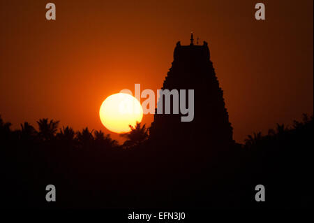 (150208)--KARNATAKA, 8. Februar 2015 (Xinhua)--die Sonne versinkt hinter dem Virupaksha Tempel von Hampi im Bellary District of India Bundesstaat Karnataka, 6. Februar 2015. Spitznamen wie "Hampi: The Lost World", die strenge, grandiose Website von Hampi war die letzte Hauptstadt des letzten großen hinduistischen Königreich von Vijayanagar. Seine sagenhaft reichen Fürsten gebaut dravidischen Tempel und Paläste, die die Bewunderung der Reisenden zwischen dem 14. und 16. Jahrhundert. Von der Deccan muslimischen Konföderation im Jahre 1565 erobert, wurde die Stadt über einen Zeitraum von sechs Monaten vor dem Verlassenwerden geplündert. Die Gruppen der Denkmäler an Stockfoto