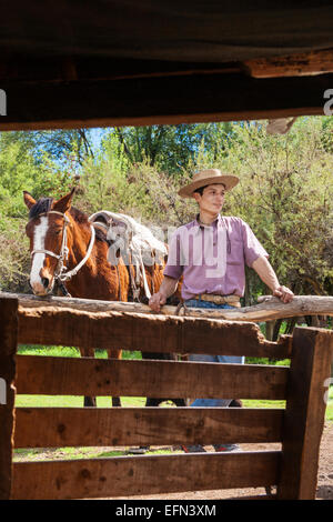 Chilenische Cowboy und sein Pferd in der Nähe von Scheune auf Ranch in El Toyo Region Cajon del Maipo, Chile, Südamerika Stockfoto