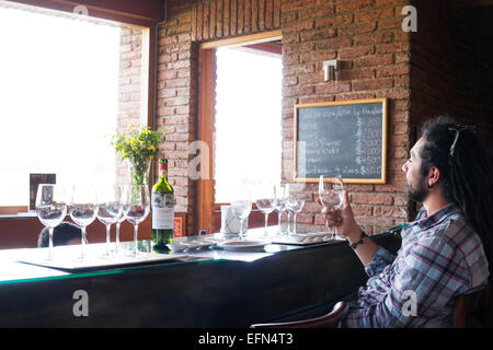 Mann hält Glas Wein im Verkostungsraum Emiliana Bio Weingut in Casablanca Valley, Chile, Südamerika Stockfoto