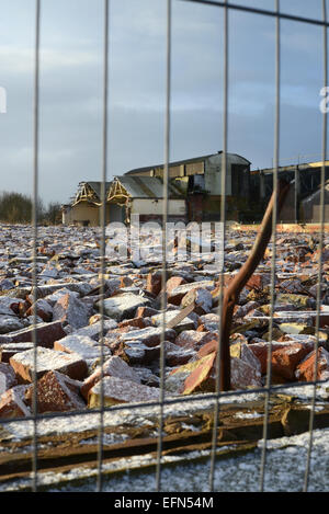 Schutthaufen auf Brachflächen und das Betriebsgebäude Winter schneebedeckt in der Nähe von Selby Yorkshire Vereinigtes Königreich Stockfoto